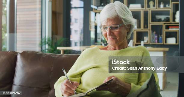 Shot Of A Senior Woman Writing In A Diary At Home Stock Photo - Download Image Now - Writing - Activity, Diary, Senior Adult