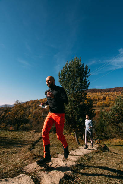 istock Young couple jogging down the stairs in autumn. 1355459584