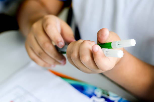 istock Hands picking up crayons to draw on paper. 1355460715