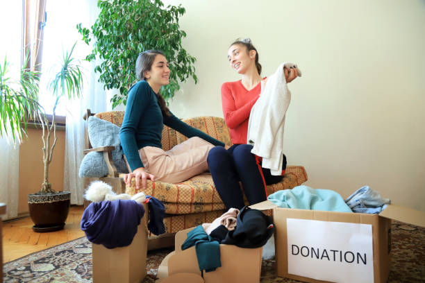 istock Two girls packing clothes for donation 1355461828