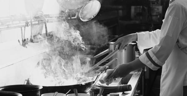 istock Chef stir fry busy cooking in kitchen 1355463419