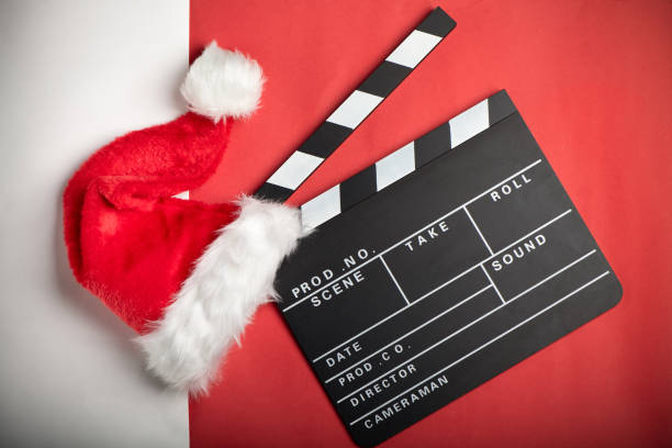 Christmas hat with film board cutout on red and white background. Christmas film. stock photo