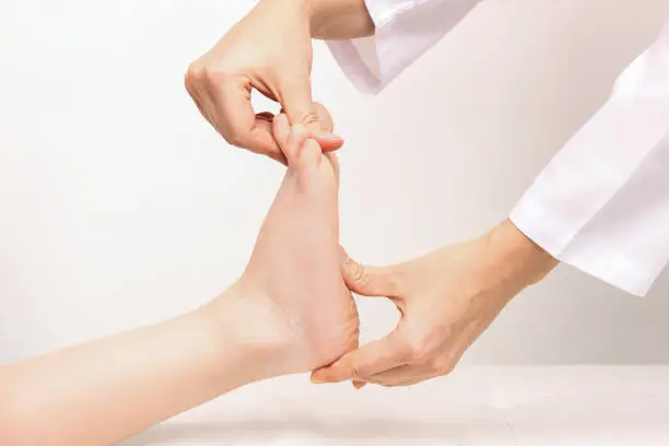 Photo of Examination of a child by orthopedist Cropped shot of female doctor holding a kids foot in her hands