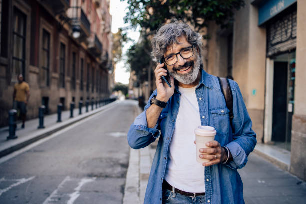 istock Mature tourist telephoning while sightseeing Barcelona 1355468202