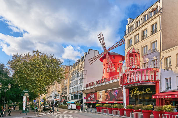 Paris Paris, France - September 29, 2021: Pedestrians at the Moulin Rouge in the Parisian district of Montmartre on Place Blanche in the 18th arrondissement, in the entertainment district of Pigalle. place pigalle stock pictures, royalty-free photos & images