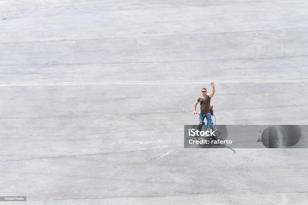 Top view of a man in sunglasses greeting while riding on a retro bike Top view of a male in sunglasses greeting while riding on a retro bike High Angle View Stock Photo