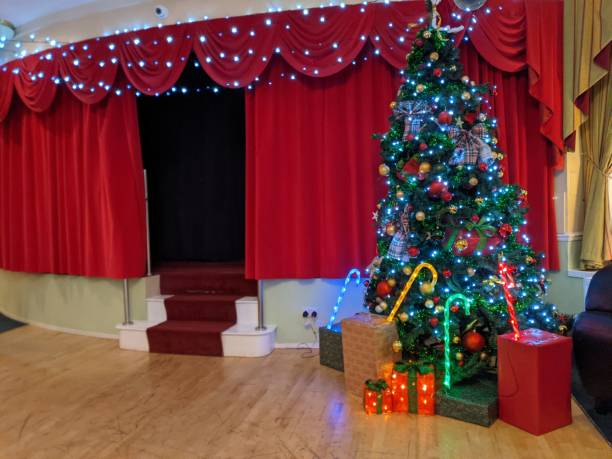 istock Christmas tree and decorations beside a red theatre curtain & stage 1355472420