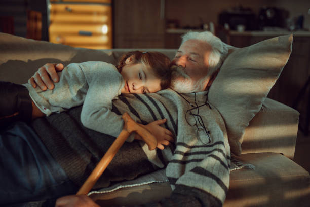 The little granddaughter and grandfather on the sofa The little granddaughter and grandfather on the sofa sleeping grandpa stock pictures, royalty-free photos & images