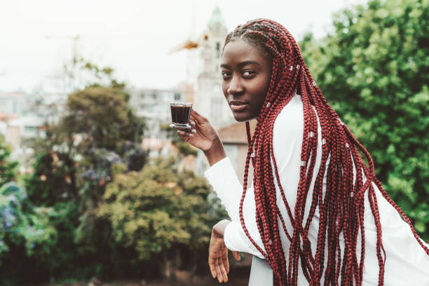 コーヒーを飲むペンシブ黒人の女の子 - braids african descent women pensive ストックフォトと画像