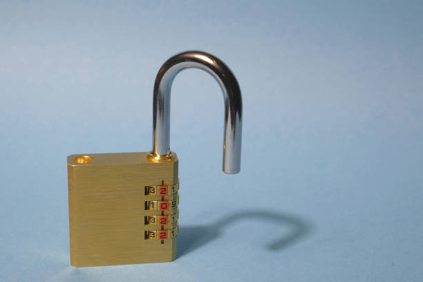 Concept. New Year. Brass yellow combination open lock on a light blue background. On disks figures 2022. Lockdown, removal of restrictions, covid.