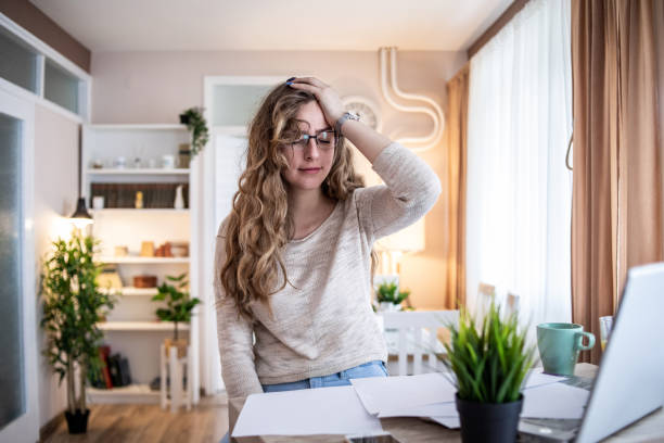istock A young student is sitting at her desk, using a laptop and papers while studying. 1355475835
