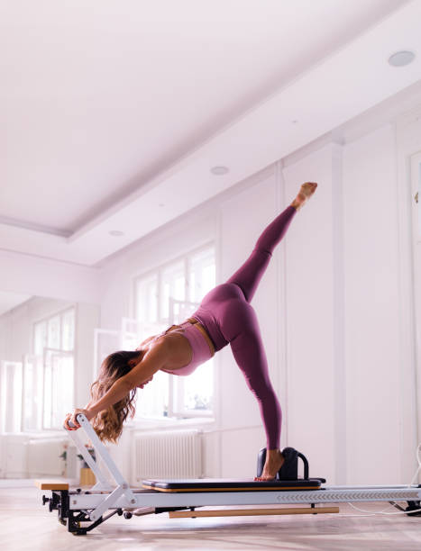 istock Female reformer exercising on a Pilates machine. 1355477182