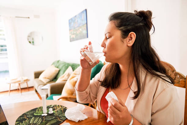 istock Shot of a young ill woman taking medication while working from home 1355479721