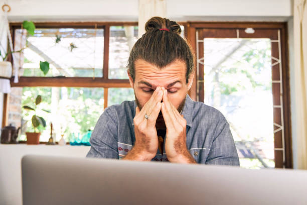 istock Shot of a young man looking stressed while working from home 1355479724