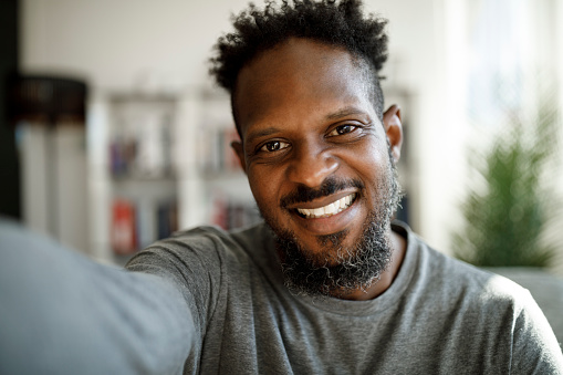 Smiling young man having online conference from home