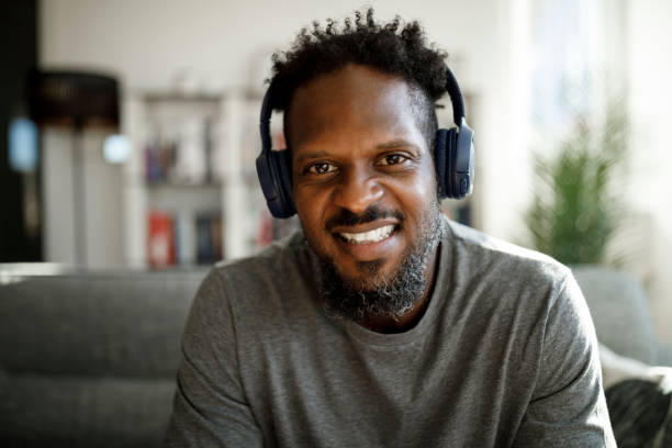 istock Smiling man with headphones having video call from home 1355480002