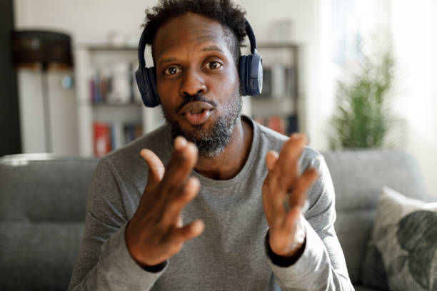 istock Smiling man with headphones having video call from home 1355481244