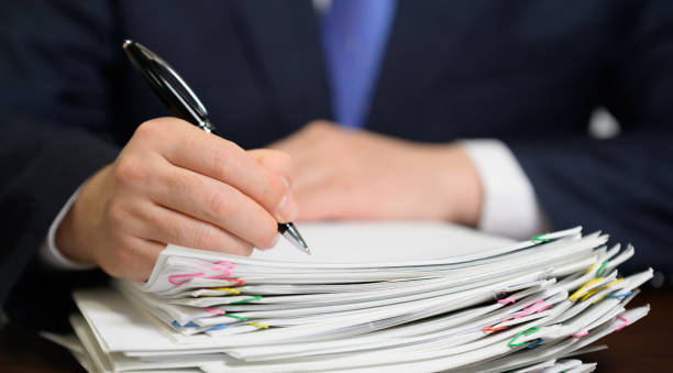 Businessman's hand holding a bundle of papers. stock photo