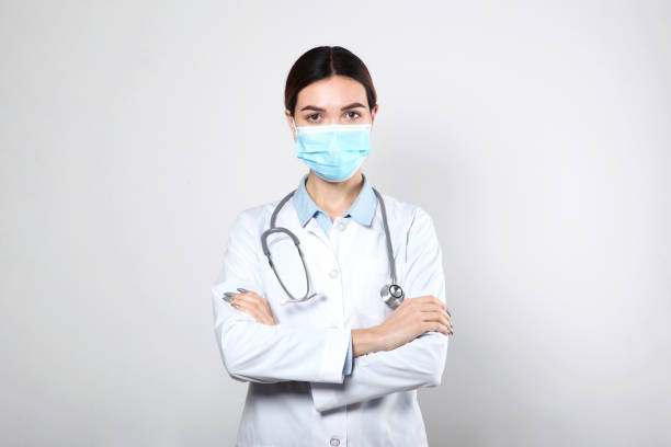 istock Young woman doctor on light background close-up 1355481816