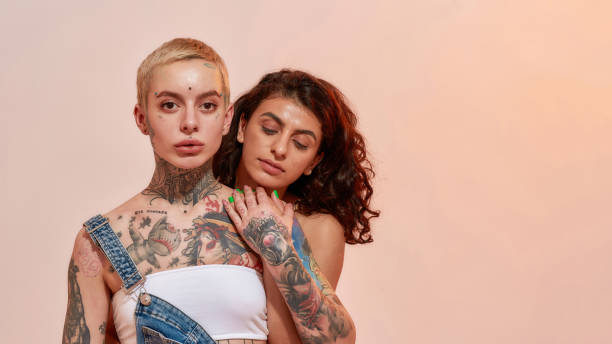 istock Young diverse women, generation Z lesbian couple embracing while posing together isolated over light pink background 1355483280