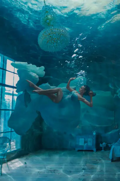 Photo of Beautiful woman in room underwater