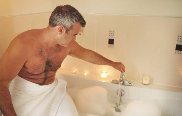 istock Shot of a mature man running himself a bath 1355485986