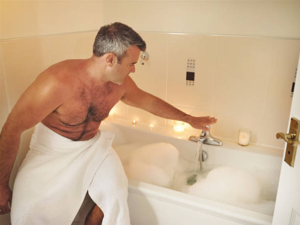 istock Shot of a mature man running himself a bubble bath 1355486119