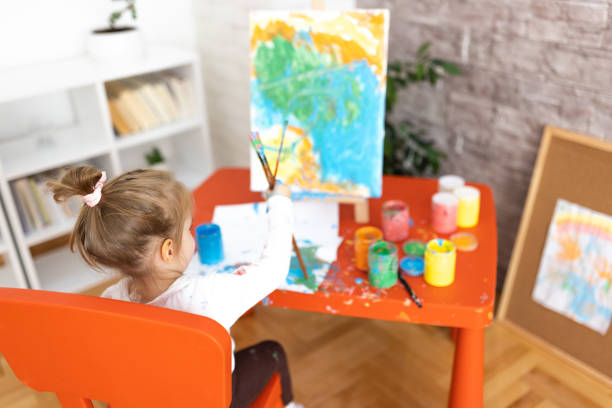 istock A little girl chooses a paintbrush 1355487713