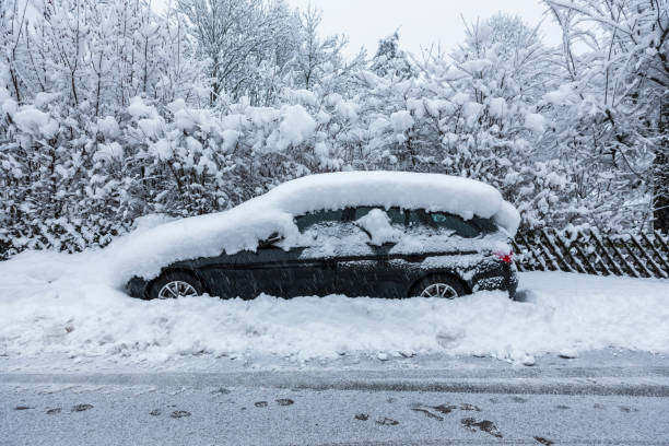 istock Snow-covered car in winter on the parking strip 1355497937