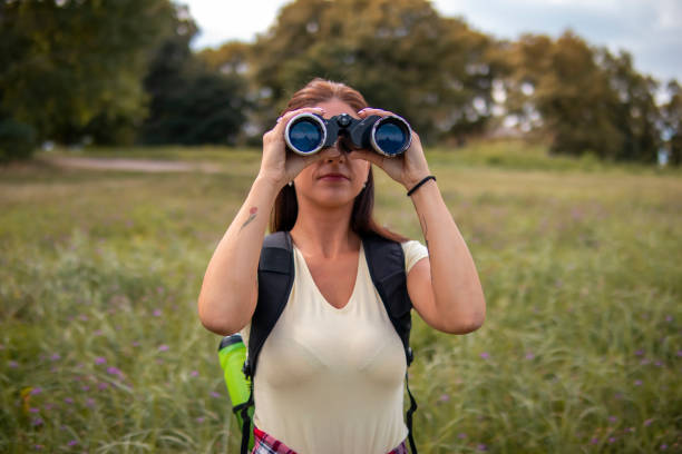 istock Woman hiking on pastures in the mountains and using binoculars 1355500768