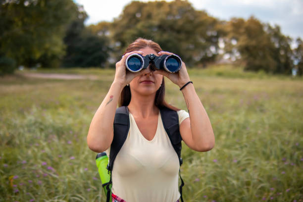 istock Woman hiking on pastures in the mountains and using binoculars 1355500816