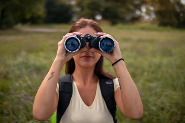 istock Woman hiking on pastures in the mountains and using binoculars 1355500900