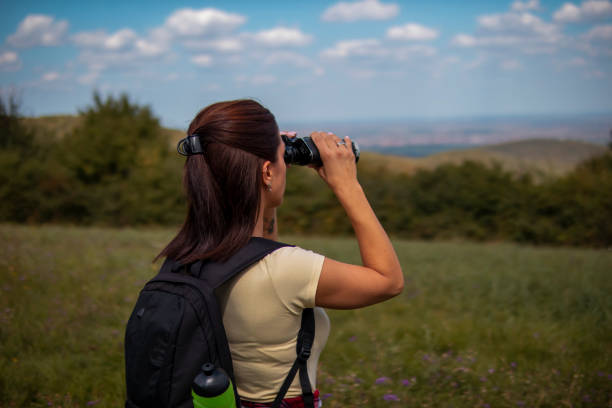 istock Woman hiking on pastures in the mountains and using binoculars 1355500953