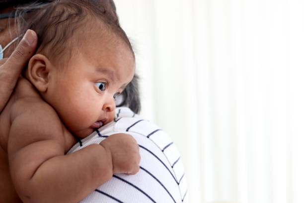 親の肩に小さなアジアのアフリカの新生児の女の子、甘い愛らしい幼児の赤ちゃんの肖像画。 - newborn baby african ethnicity little girls ストックフォトと画像