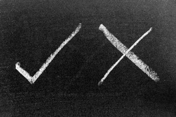 White color chalk hand drawing in check mark of right and wrong shape on black board background