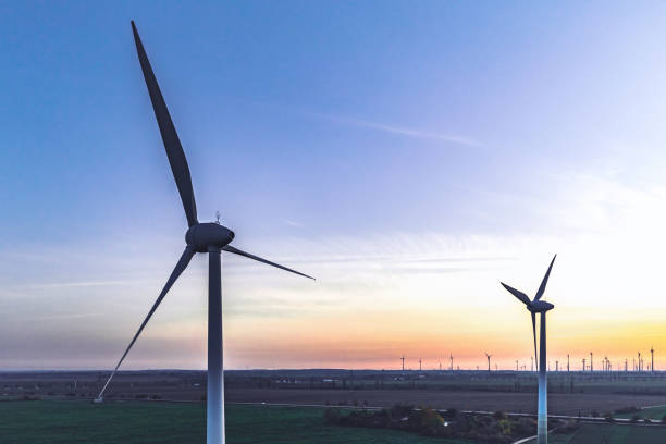 istock wind turbines in sunset landscape 1355502132