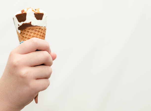 istock kid eating ice cream wafer cone with happiness 1355502297