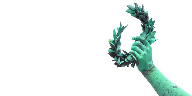 Photo of Hand holds a laurel wreath - bronze statue success and fame concept image with copy space