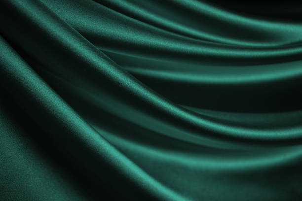 blue green silk satin. soft, wavy folds. shiny fabric surface. luxurious emerald green background with copy space for design. web banner. - satin blue dark textile imagens e fotografias de stock