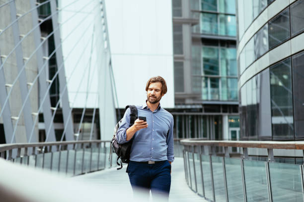 istock Mature businessman in full suit using smart phone in financial district during lockdown 1355507961