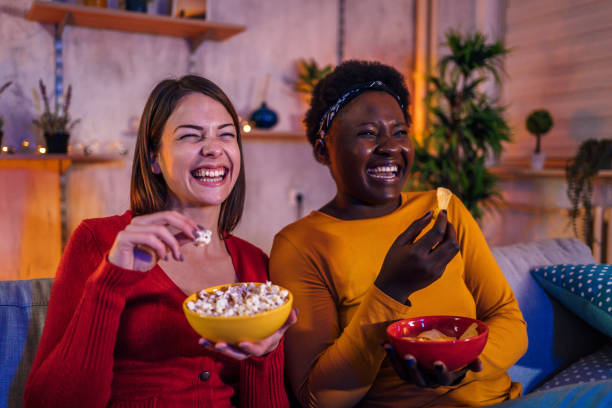 istock Female friends watching comedy movie 1355508021