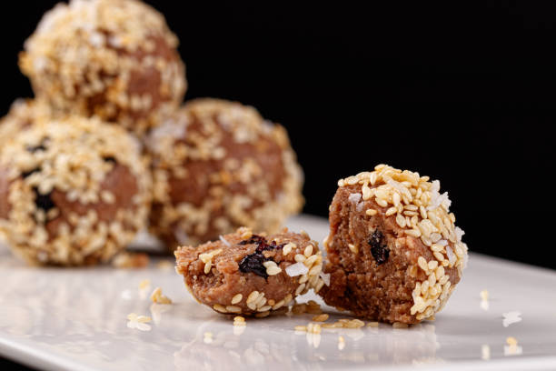 istock Beautiful candies with sesame seeds on a white plate on a black background 1355508193