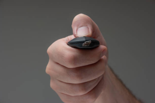 caucasian male hand holding a car key fob. close up studio macro sho - studio sho imagens e fotografias de stock