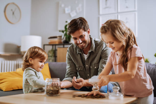 vater mit spielender tochter - currency savings coin counting stock-fotos und bilder