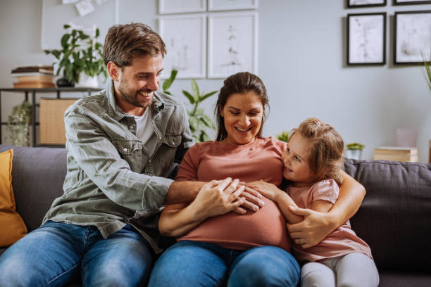 istock Daughter and husband touching pregnant woman's belly 1355514897