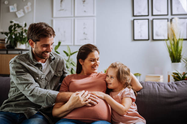 istock Daughter and husband touching pregnant woman's belly 1355514936