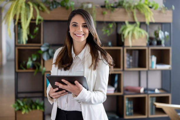 erfolgreiche geschäftsfrau mit einem tablet-computer im büro - businesswoman stock-fotos und bilder