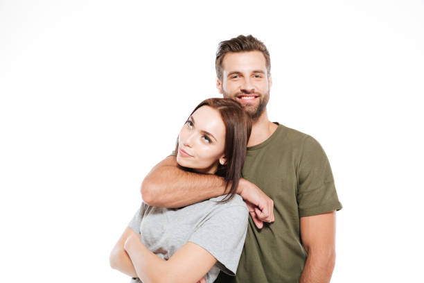 istock Happy young loving couple standing isolated 1355517015
