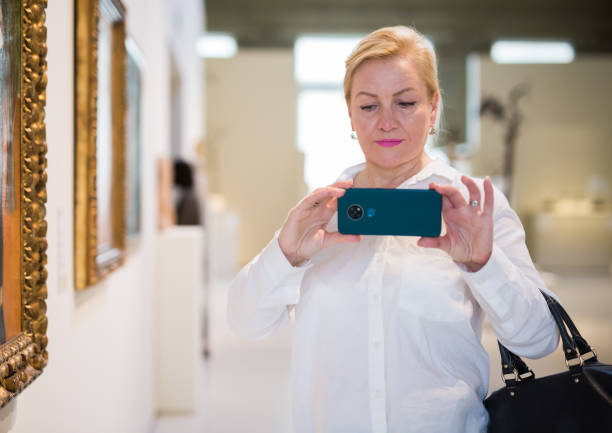 istock Female visitor taking picture in art gallery 1355517076