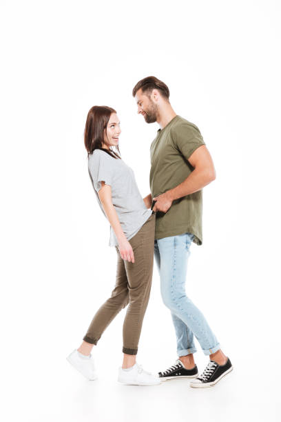istock Happy young loving couple standing isolated 1355518741
